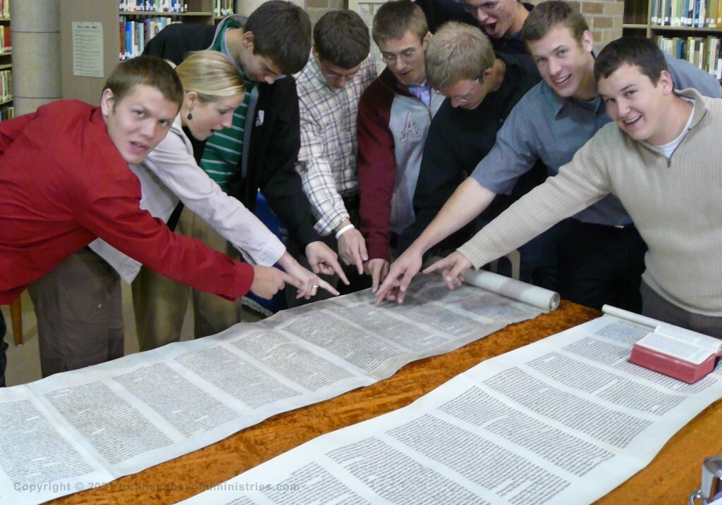 Students are pointing to Isaiah chapter 53 in the Scroll of Isaiah.